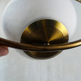 Eleganten nordijski viseči lampa z zlatim telesom in steklenim senčilom, višinsko nastavljiv za plemenito vzdušje